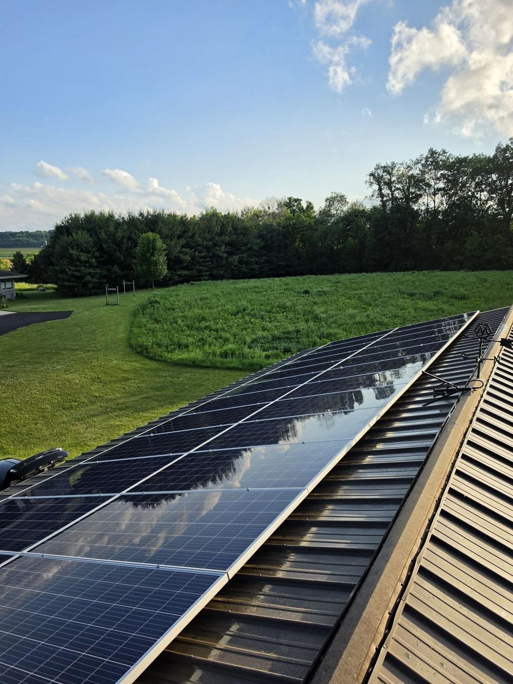 Same Baraboo farm-adjacent solar panels after a Solar Alchemist cleaning — mirror reflection of the sky