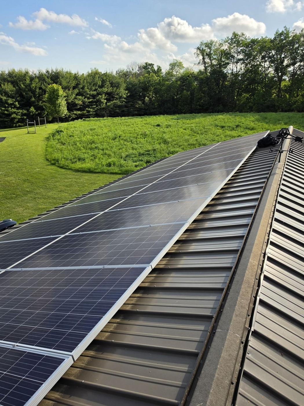Farm-adjacent solar panels in Baraboo right after a heavy rainfall — still streaked with field dust and pollen